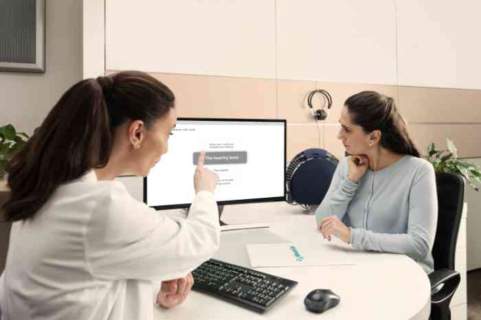 Ein Großvater liest seinem Enkel ein Buch auf dem Sofa vor, die Großmutter ist daneben