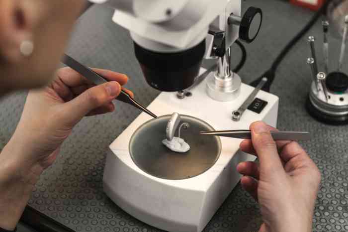 A hearing aid is examined under a microscope