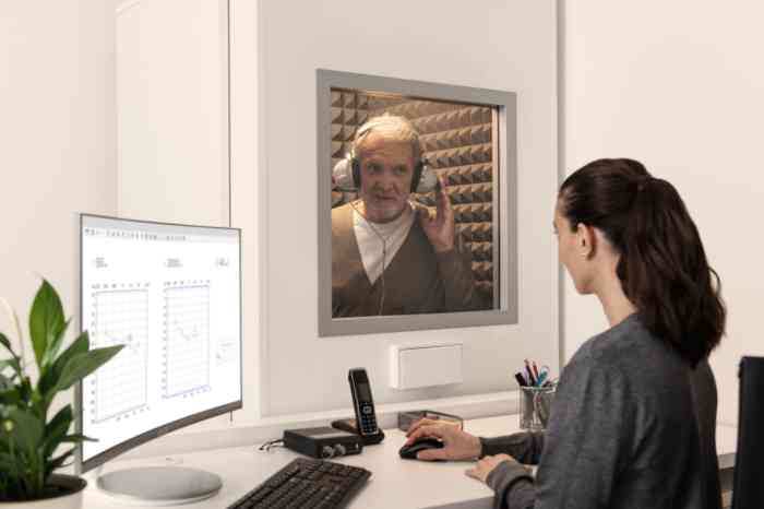 Amplifon audiologist and senior man wearing headphones during a free hearing test