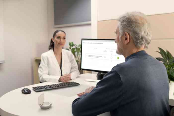 A hearing care professional visiting a man