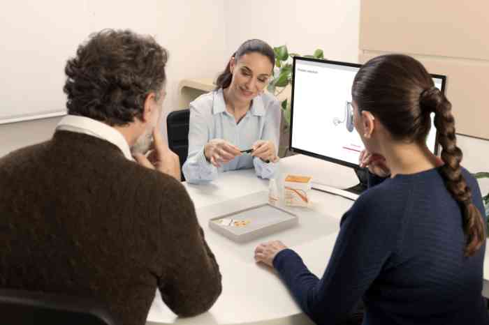 Experte Amplifon montrant des piles et des produits de nettoyage à un couple