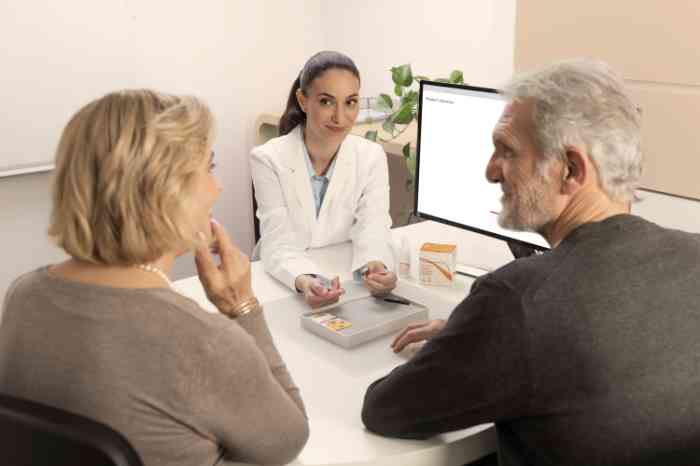 Amplifon's audiologist giving a pair of hearing aids to customers