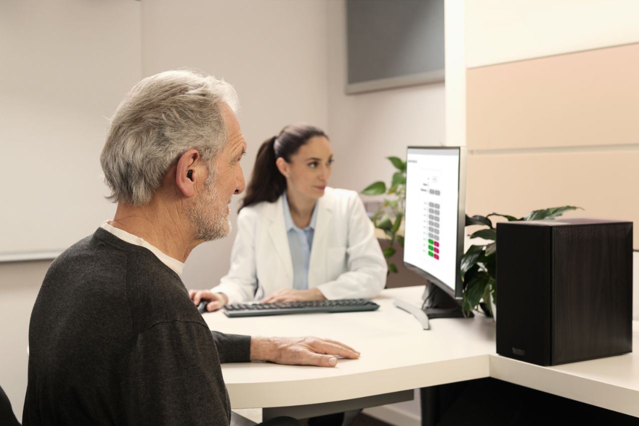 Homme âgé effectuant un test auditif avec une experte Amplifon
