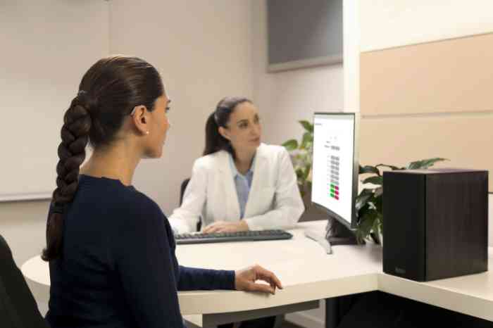 A hearing care professional helps a client taking care of her hearing aids