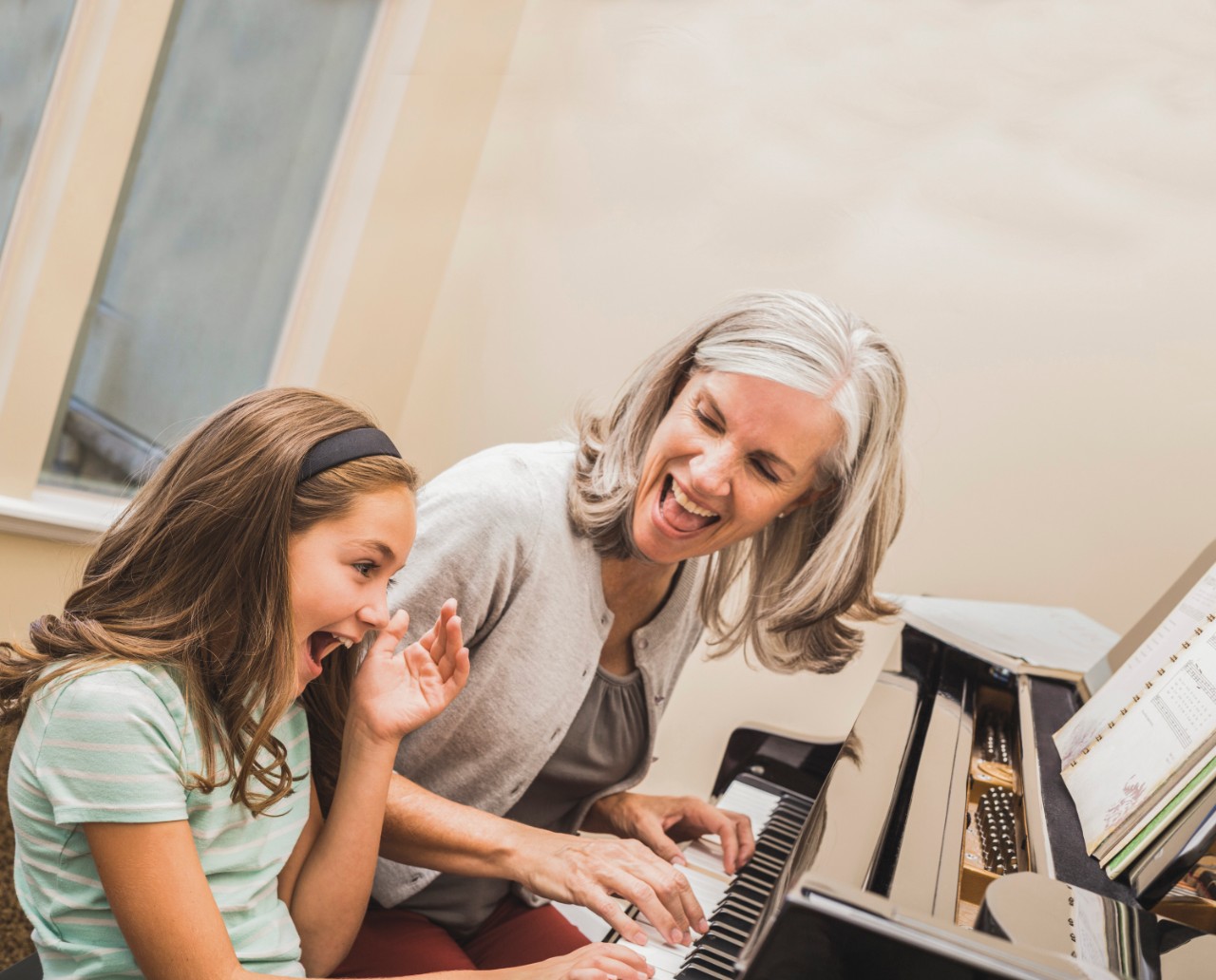 Grand-mère et petite-fille jouent au piano.