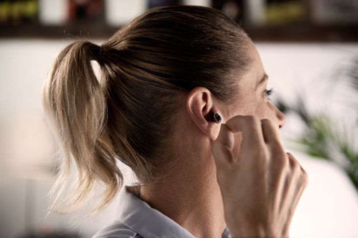 woman placing hearing aid