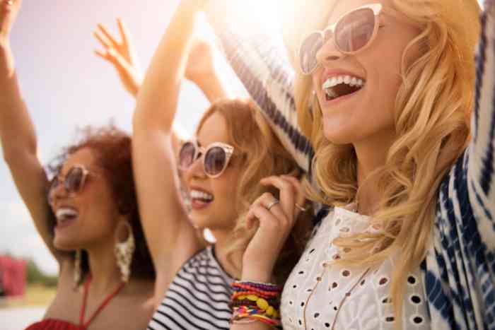 Three young girls with sunglasses smiling and having fun 