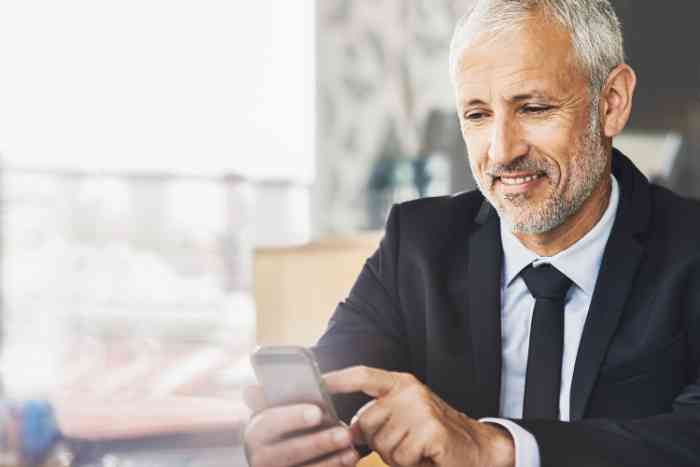 A man is tuning up his hearing aid via app for smartphone