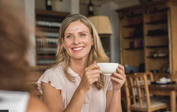 A woman in a café is drinking her coffee listening the world around