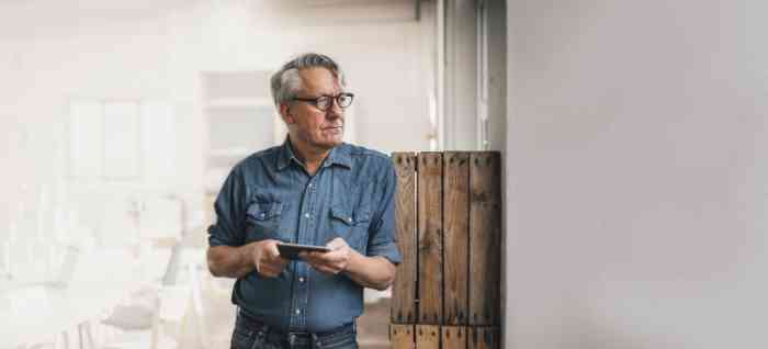 A senior man with glasses and denim shirt: hearing loss is an age common condition