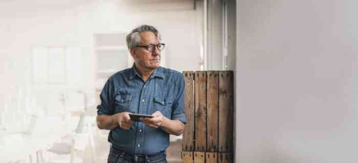 A senior man with glasses and denim shirt