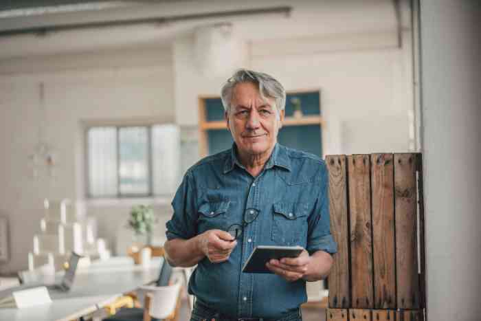 A senior man with glasses and denim shirt