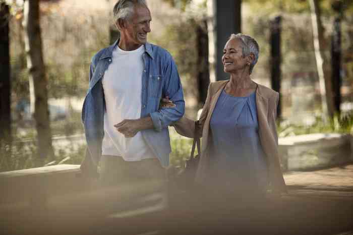 A man and a woman enjoy a walk in the nature laughing together