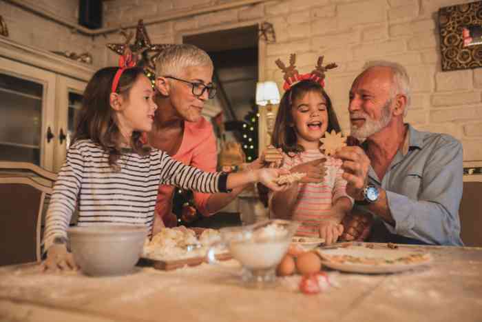 grands-parents et deux petits-enfants faisant des biscuits de Noël.