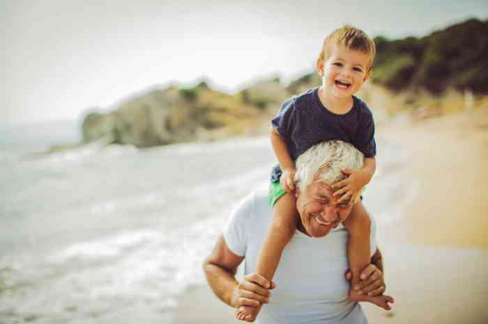 A grandfather playing with his grandson on the beach