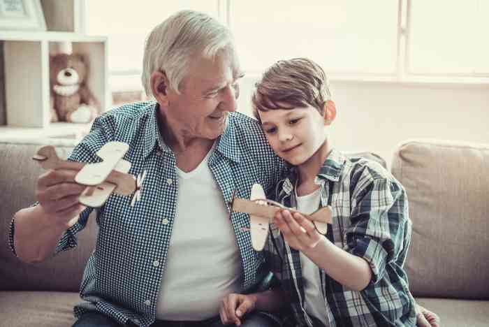 Grandfather and grandson playing with toy airplane