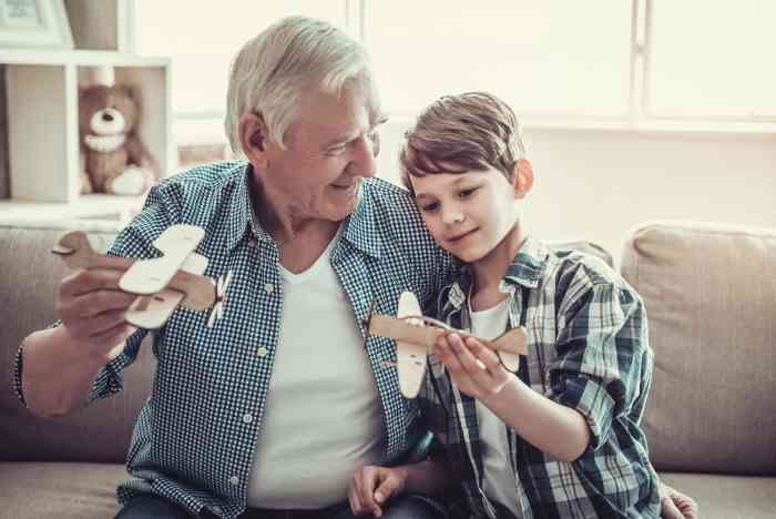 Grandfather and grandson playing with toy airplane