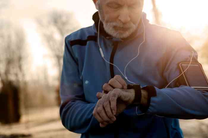 A man is ready for jogging with his earphones, smartphone and smartwatch