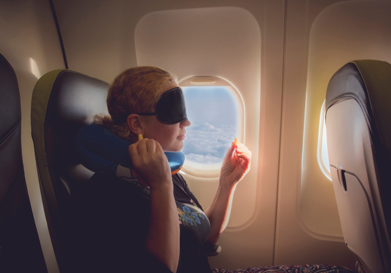 donna in aereo con cuscino e mascherina per la luce.
