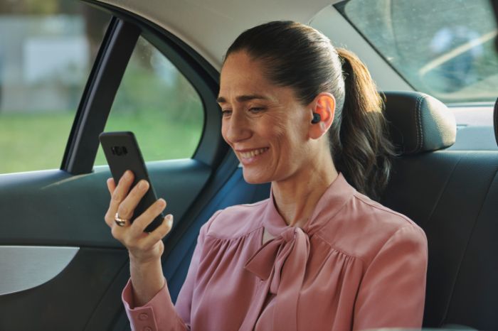 woman with phone and bluetooth hearing aids
