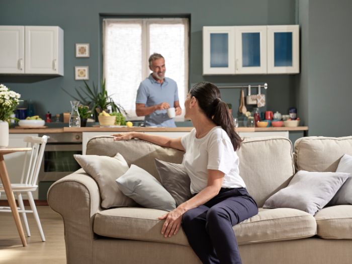 Eine Frau auf dem Sofa spricht mit einem Mann