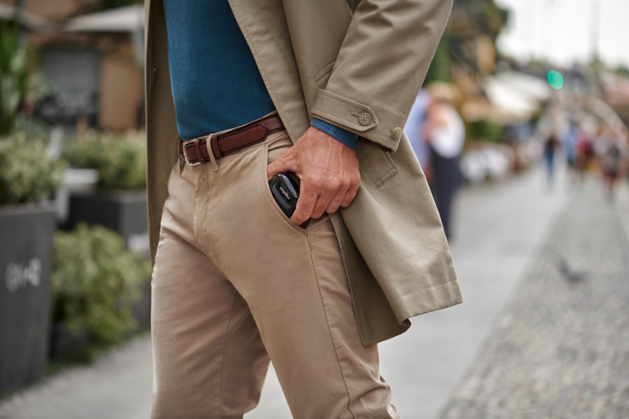 Homme avec un chargeur d'appareil auditif dans sa poche