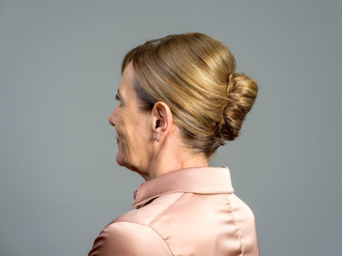 Femme de profil avec un appareil auditif 