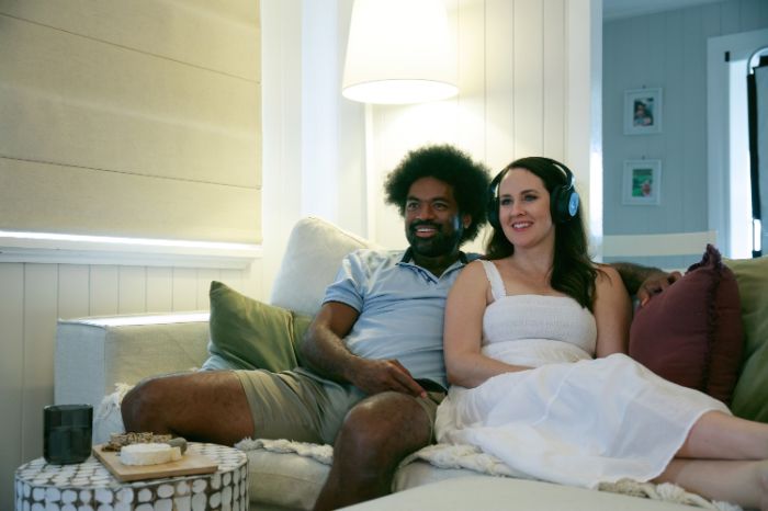 Couple sur le canapé dans la cuisine regardant la télévision