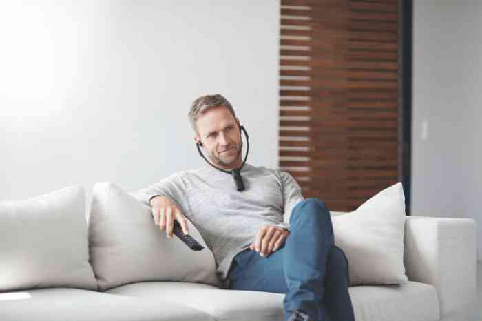 Uomo guarda la tv indossando delle cuffie sottomento