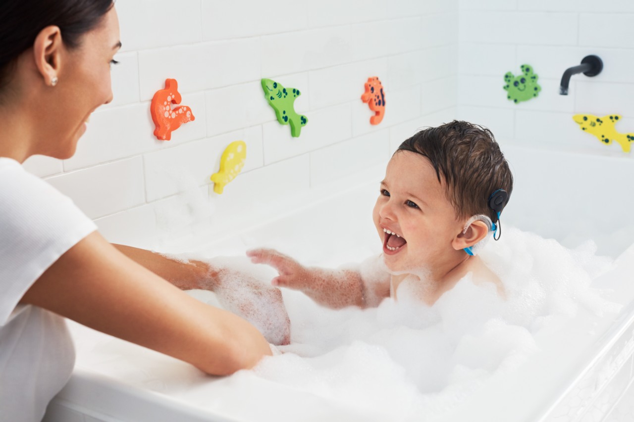 Maman fait prendre un bain à son bébé