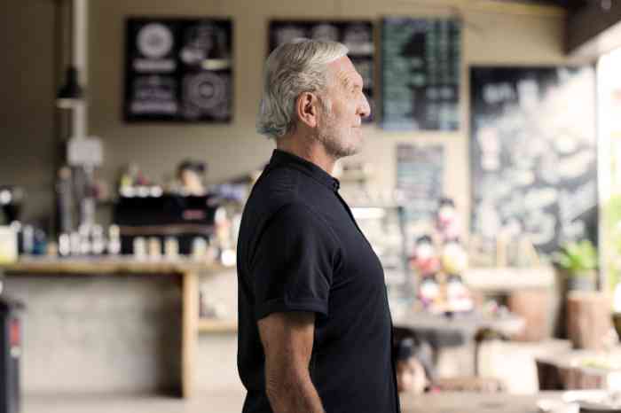 Profil eines älteren Mannes in einer Bar mit Amplifon RIC-Hörgerät.