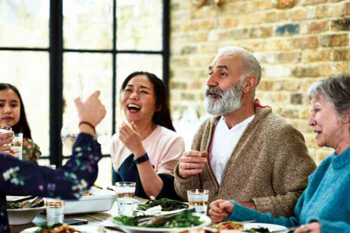 Una famiglia sorridente si ritrova a tavola per cena