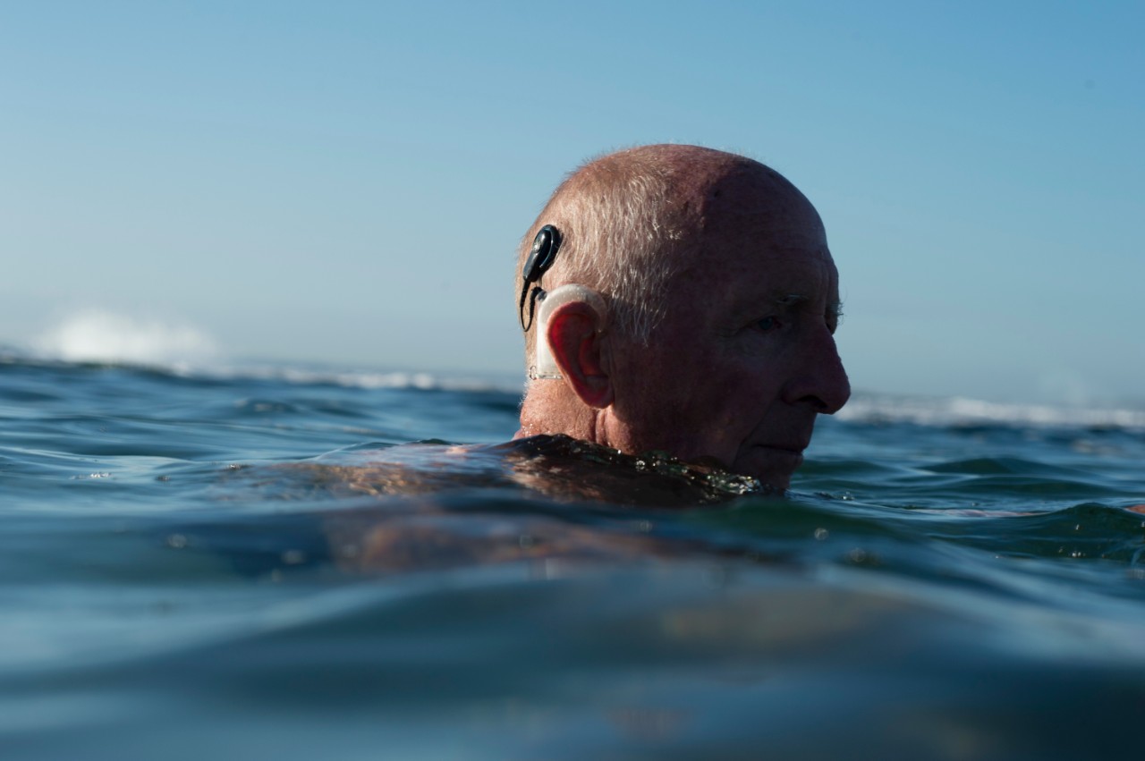 Person, die mit Hörgerät schwimmt