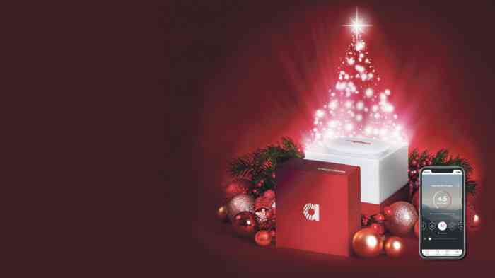 Image sur le thème de Noël avec des cadeaux Amplifon et un smartphone avec l'application Amplifon. 